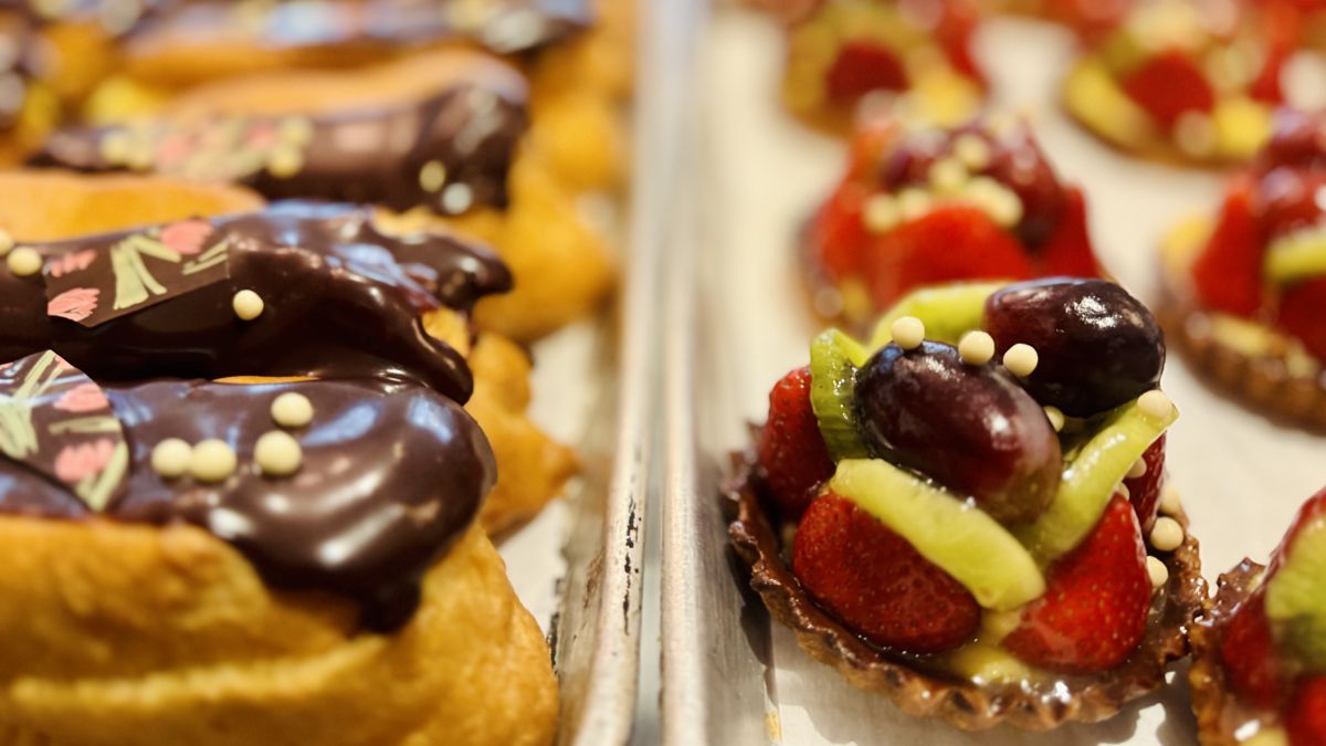 Chocolate eclairs and fruit tarts display